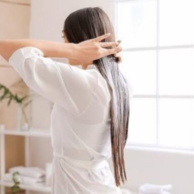 Woman with long, smooth hair receiving professional hair care treatment